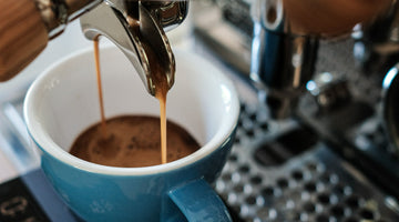 Espresso being extracted into a blue mug