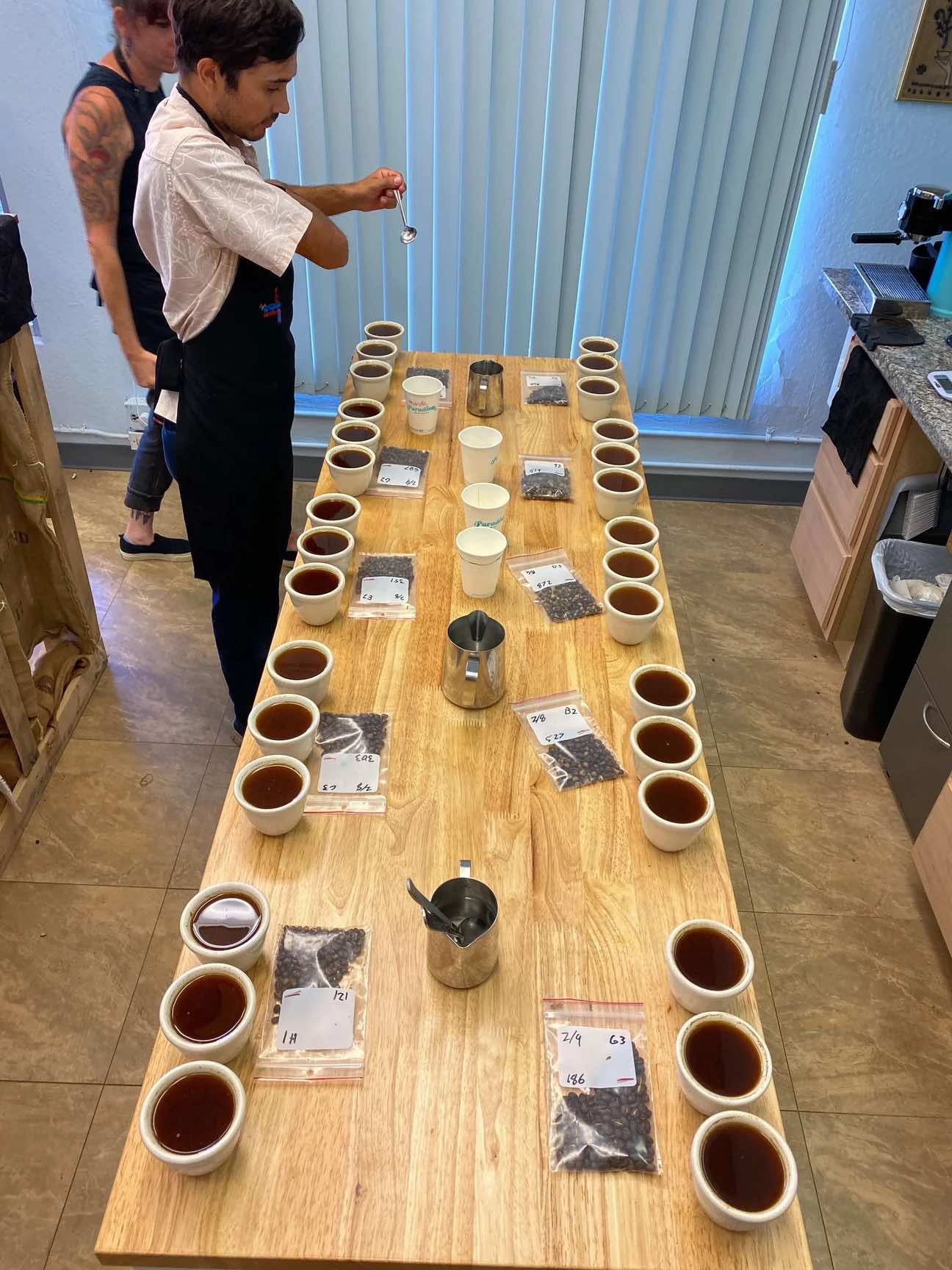 Coffee cupping table with Kona coffee samples being evaluated by tasters