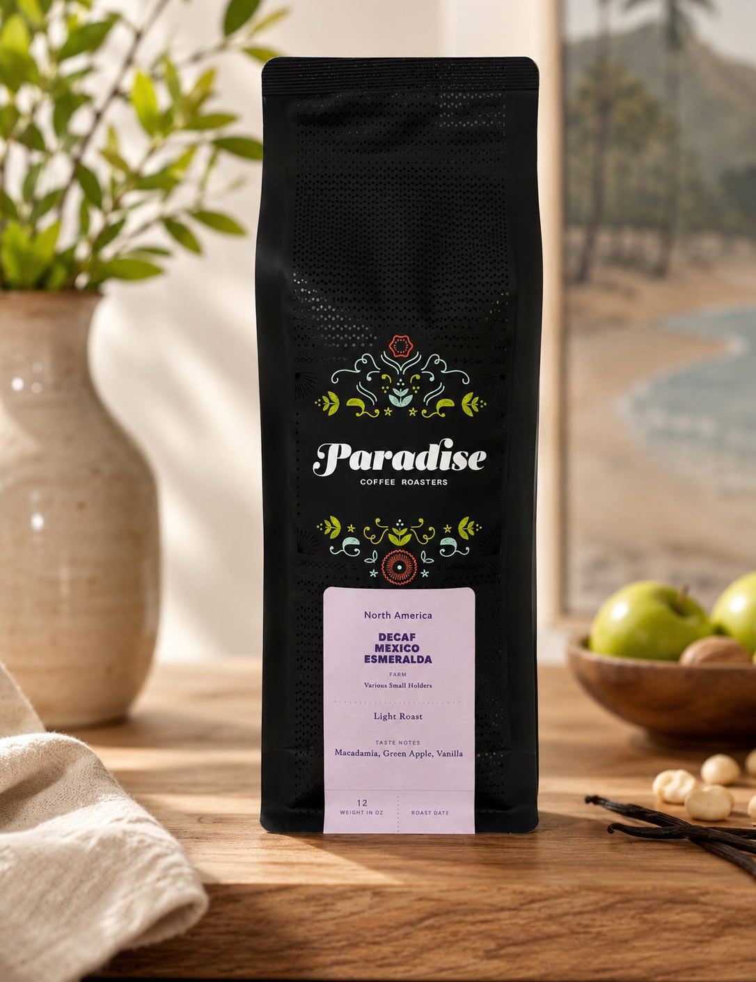 Black coffee bag with 'Paradise Coffee Roasters' branding on a wooden surface.