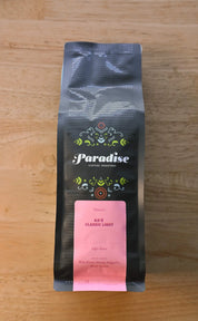 Paradise Roasters Kaʻu Classic Light coffee bag, 12oz, showing pink label with tasting notes Wildflower Honey, Magnolia, and Meyer Lemon