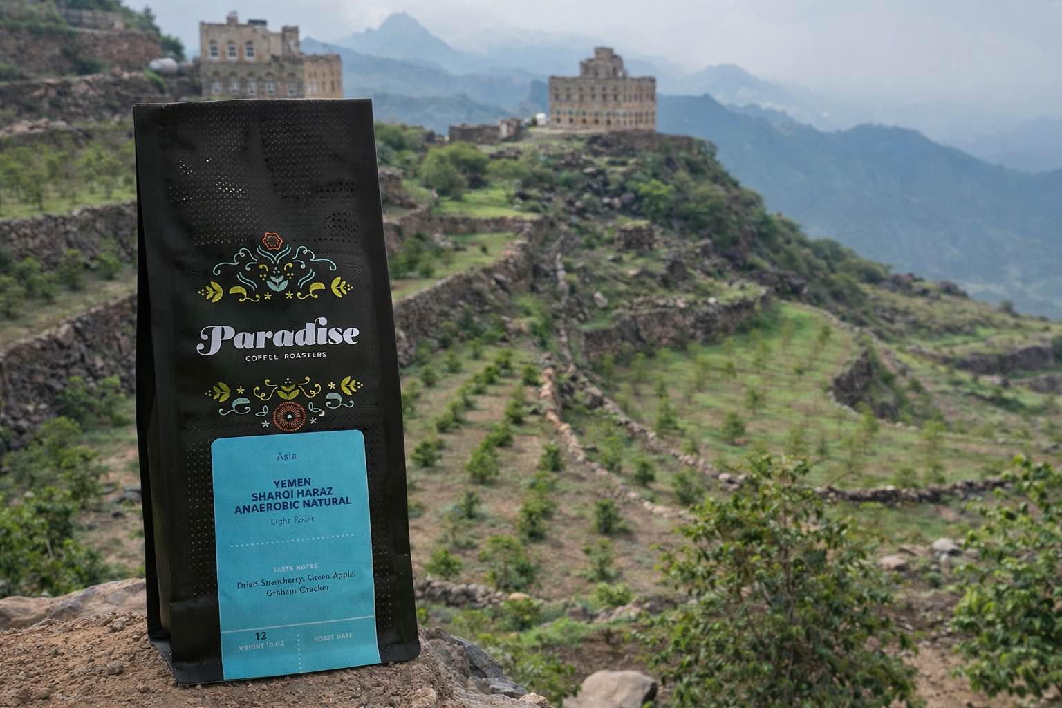 Paradise coffee bag in front of terraced yemen coffee farm